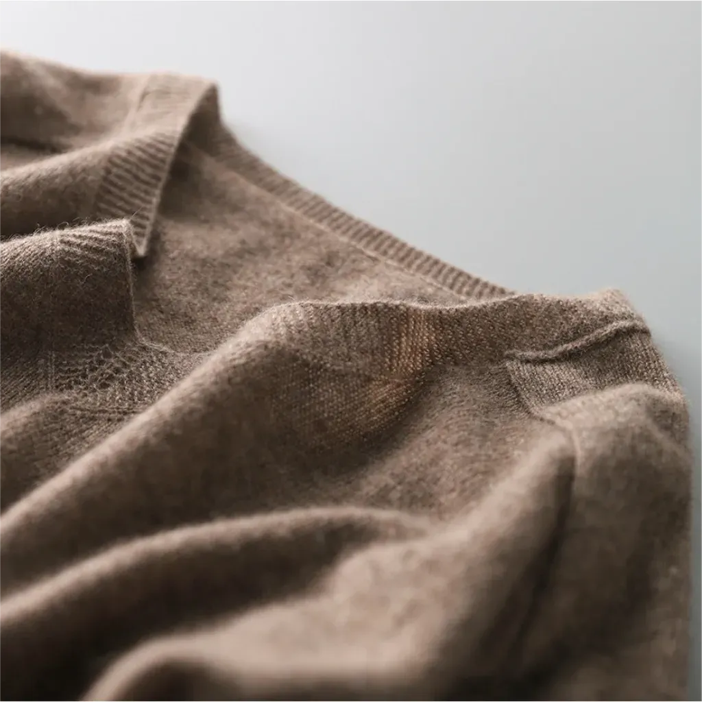 Close-up of a brown knitted sweater on a light gray background