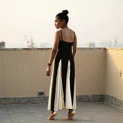 Woman in a black and white dress standing on a rooftop with a cityscape in the background