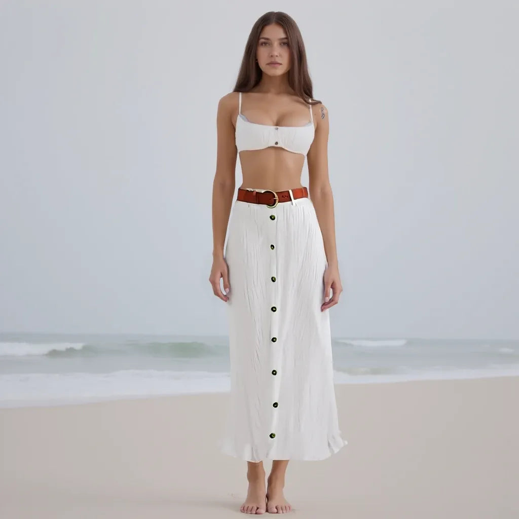 Woman wearing a white outfit with a belt on a beach
