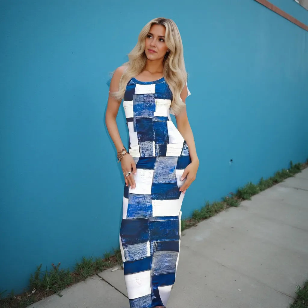 Woman wearing a blue and white patchwork dress against a blue wall.