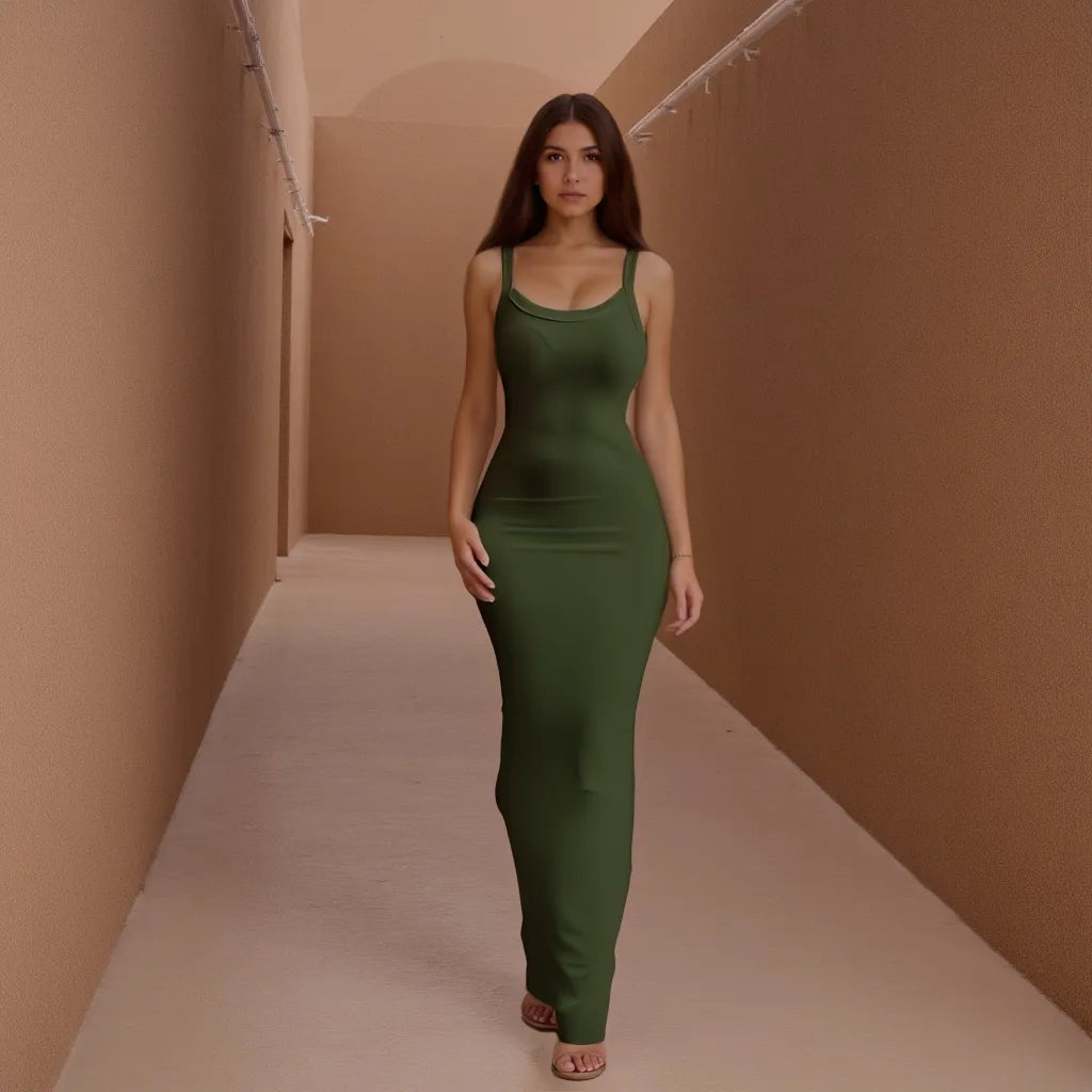 Woman in a green dress standing in a narrow hallway with beige walls.