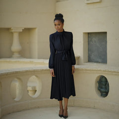 Woman in a black dress standing in an architectural setting
