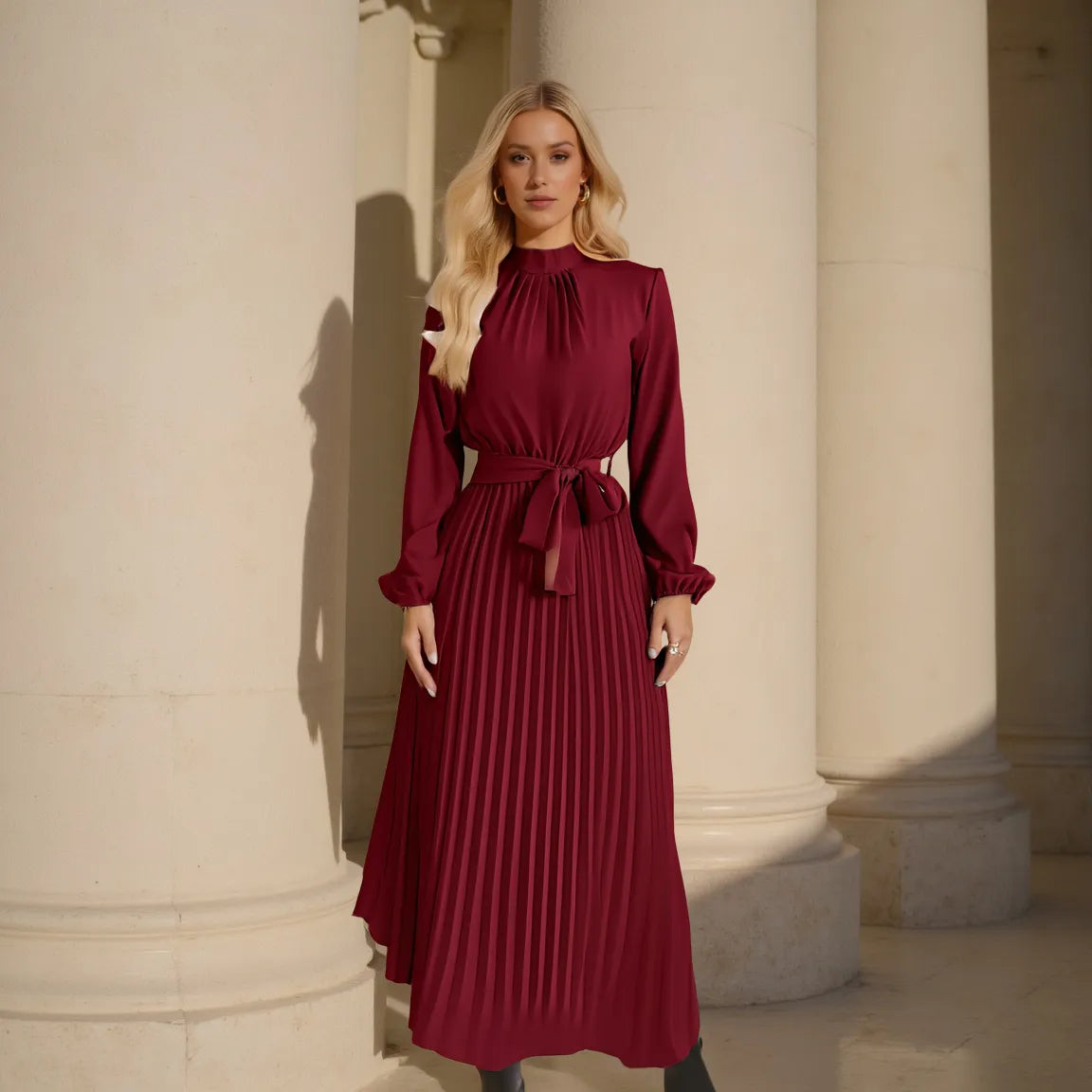Woman in a burgundy dress standing between classical columns