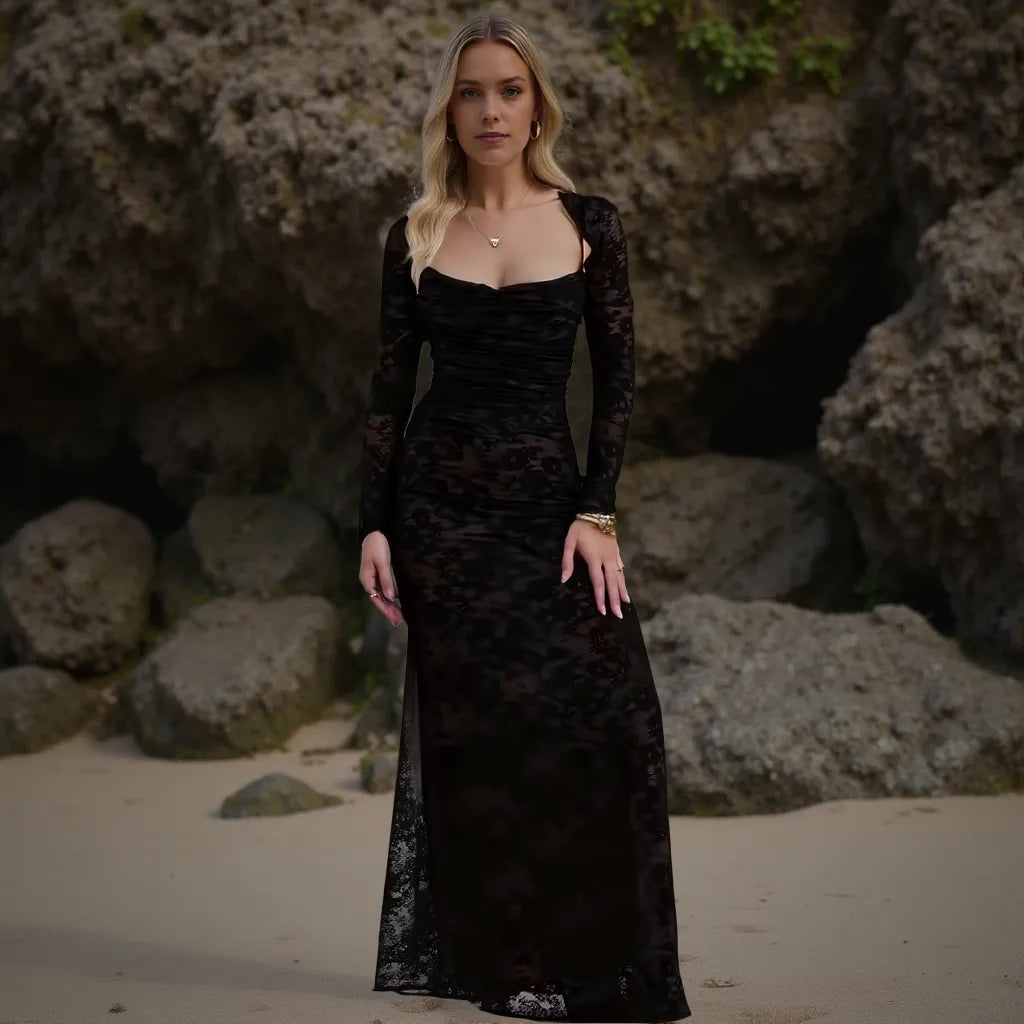 Woman in a black dress standing on a rocky beach