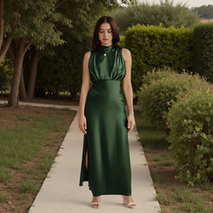 Woman in a green dress standing on a path with greenery around