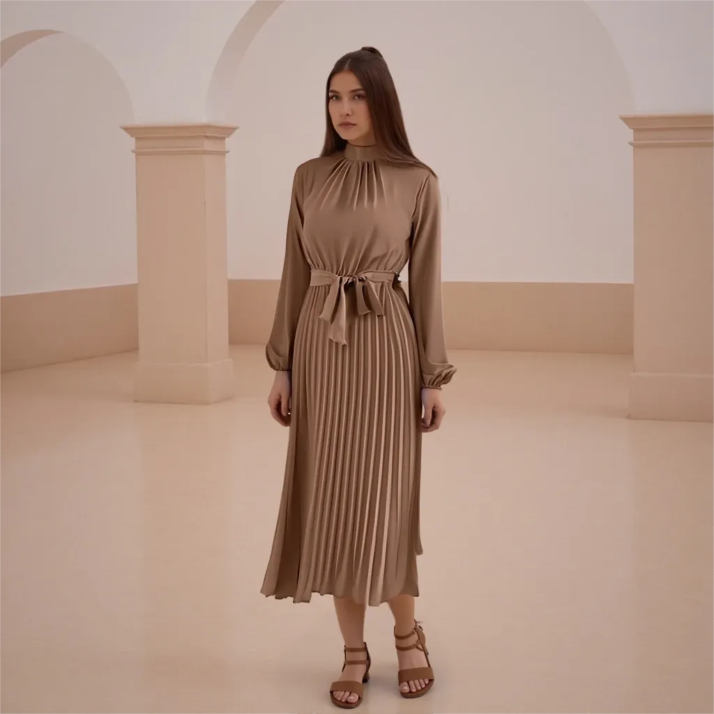 Woman wearing a brown dress standing in an elegant interior setting