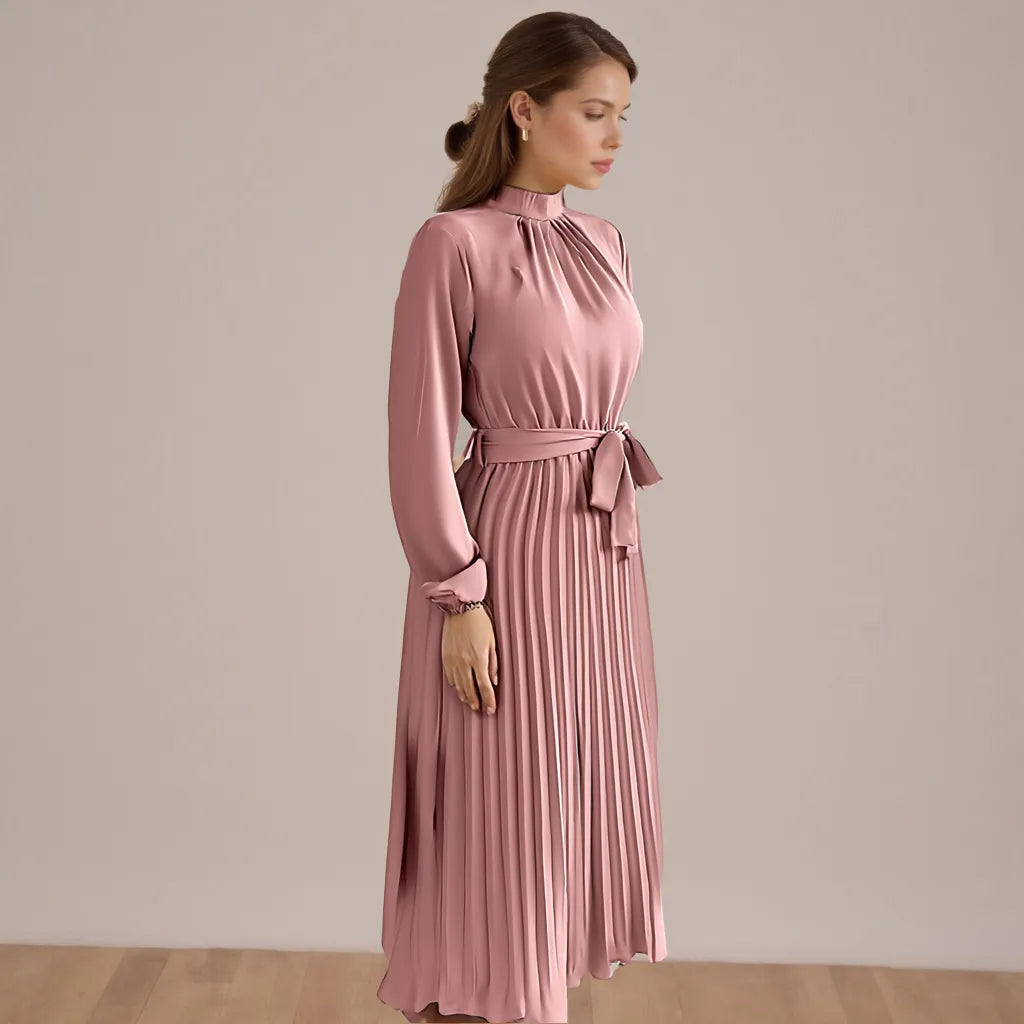 Woman wearing a pink dress with a belt against a beige background