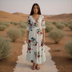 Woman in a floral dress standing in a desert landscape