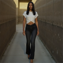 Woman in a white top and black pants walking between two concrete walls.