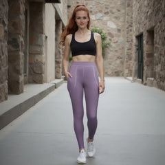 Woman wearing a black sports bra and purple leggings standing in a stone-walled corridor.