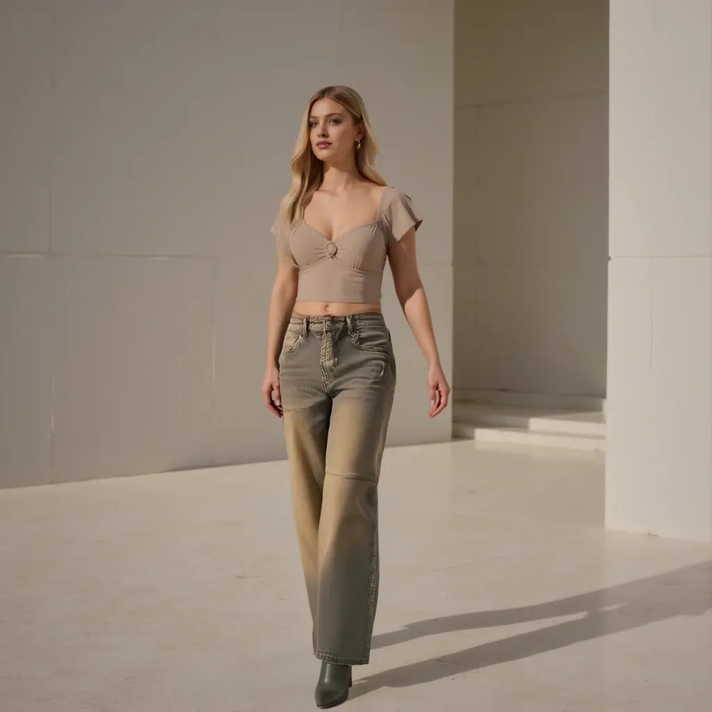 Woman wearing a beige top and green pants in a minimalistic setting