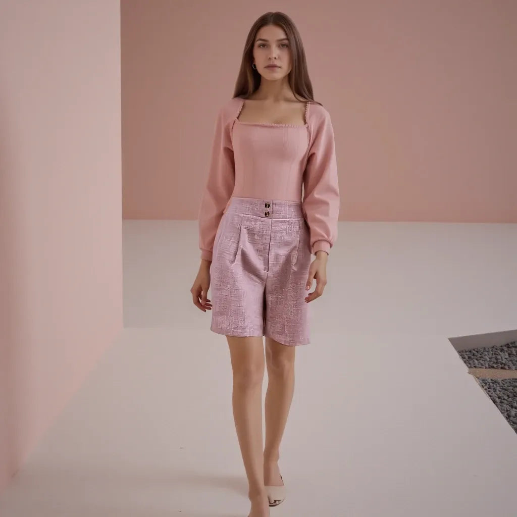 Woman wearing a pink outfit with a matching top and skirt against a plain background