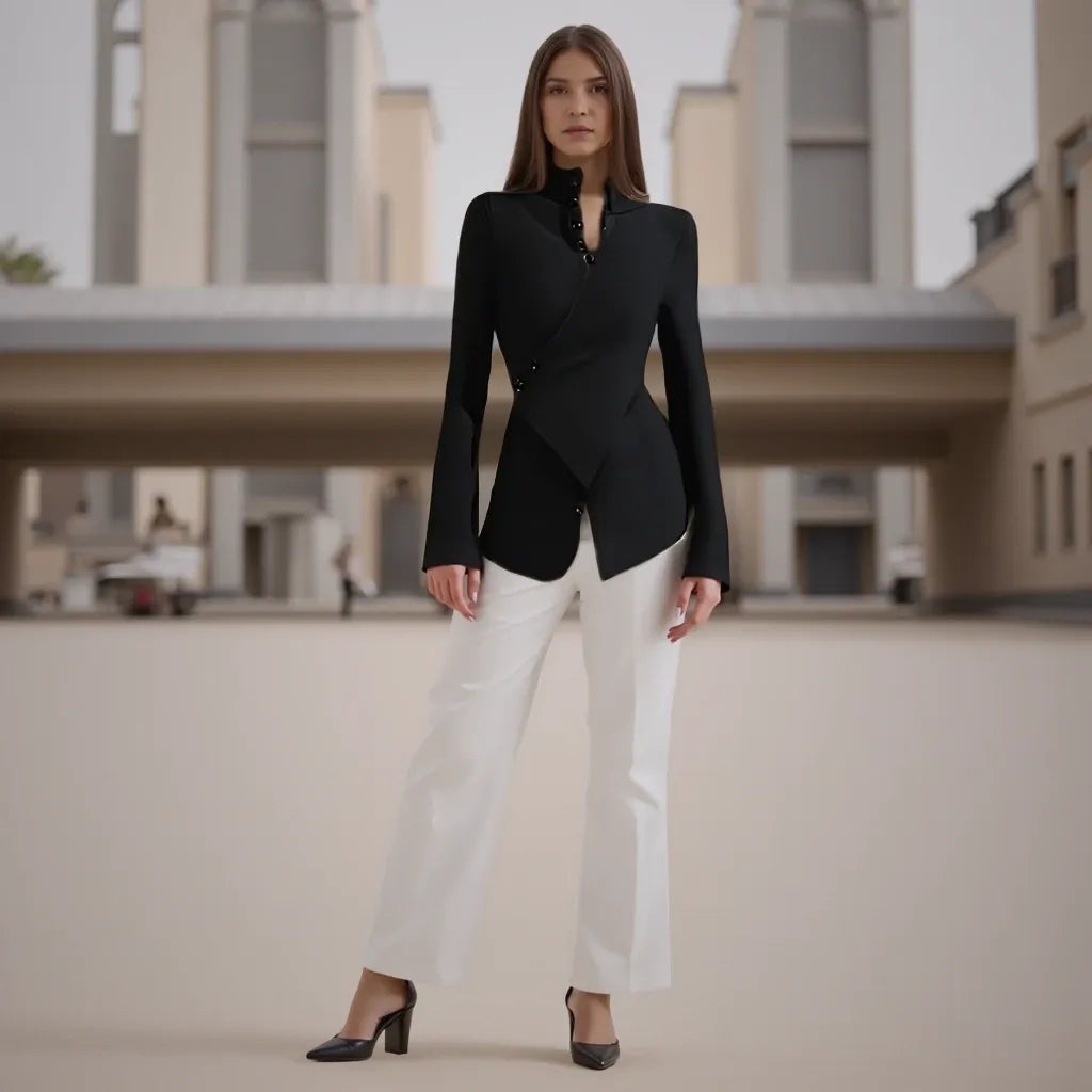 Woman wearing a black blazer and white pants standing in front of a building.