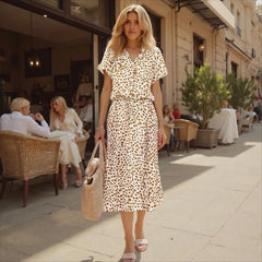 Woman in a leopard print dress walking on a city street.