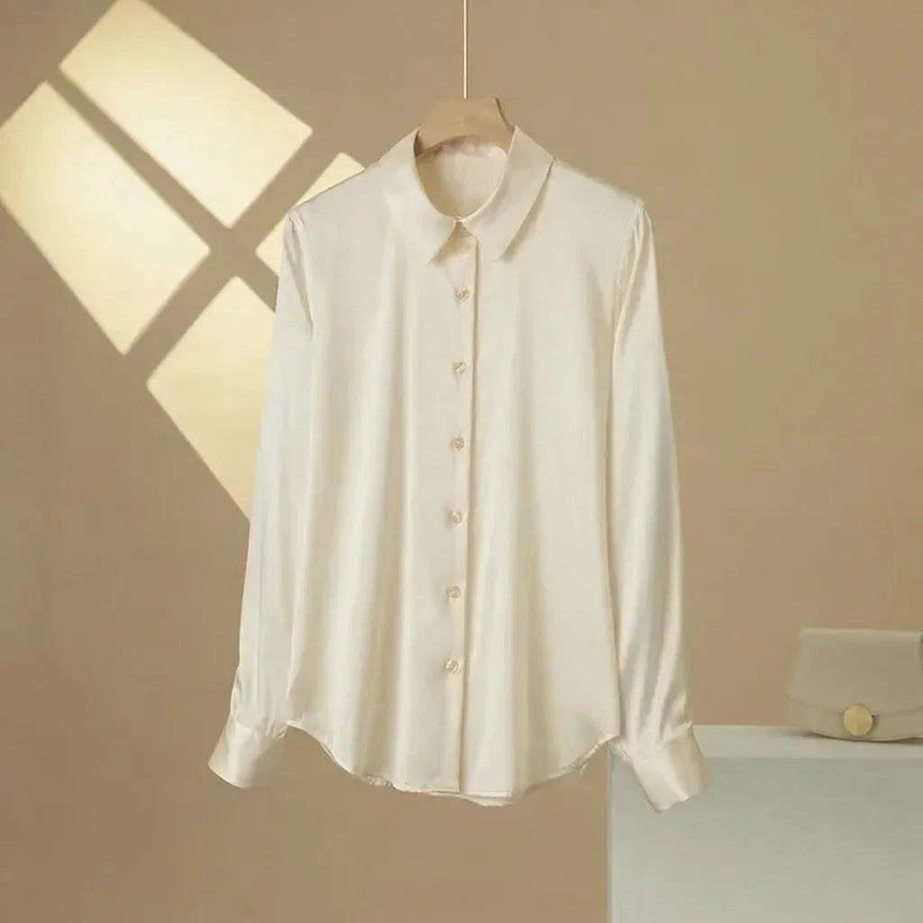 White shirt on a hanger against a beige wall