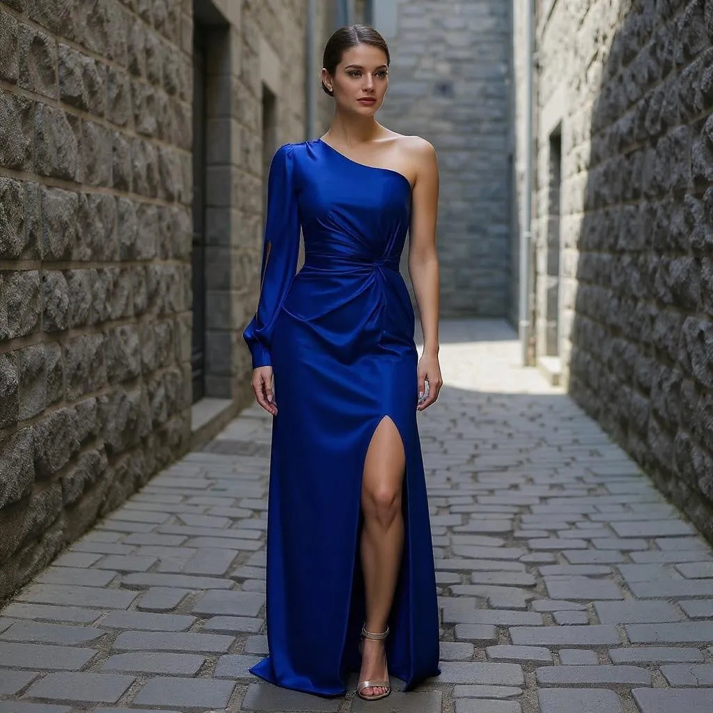 Woman in a blue one-shoulder dress standing in a stone alleyway.