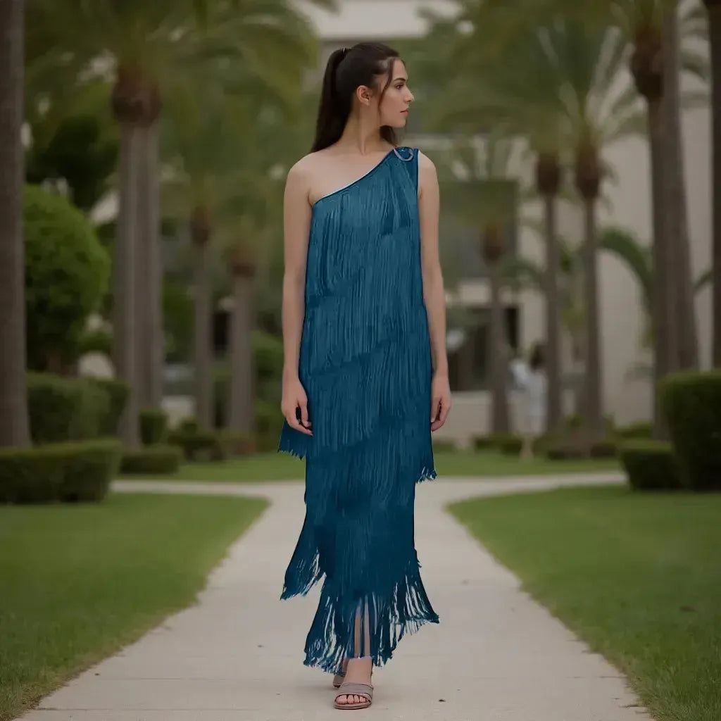Woman in a blue fringe dress walking on a path with palm trees in the background