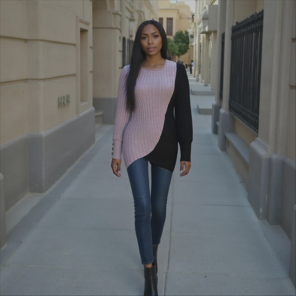 Woman walking down a city street wearing a pink sweater and black cardigan.