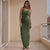 Woman wearing a green dress standing in a room with a neutral color scheme.
