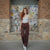 Woman standing in front of a stone wall with vintage comic books displayed.