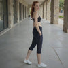 Woman in athletic wear standing on a stone pathway