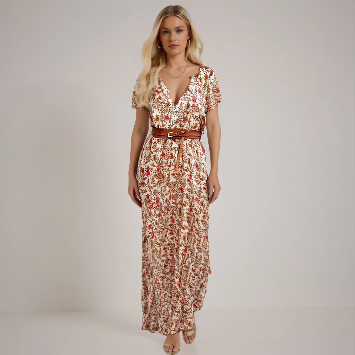 Woman wearing a floral dress with a belt on a plain background