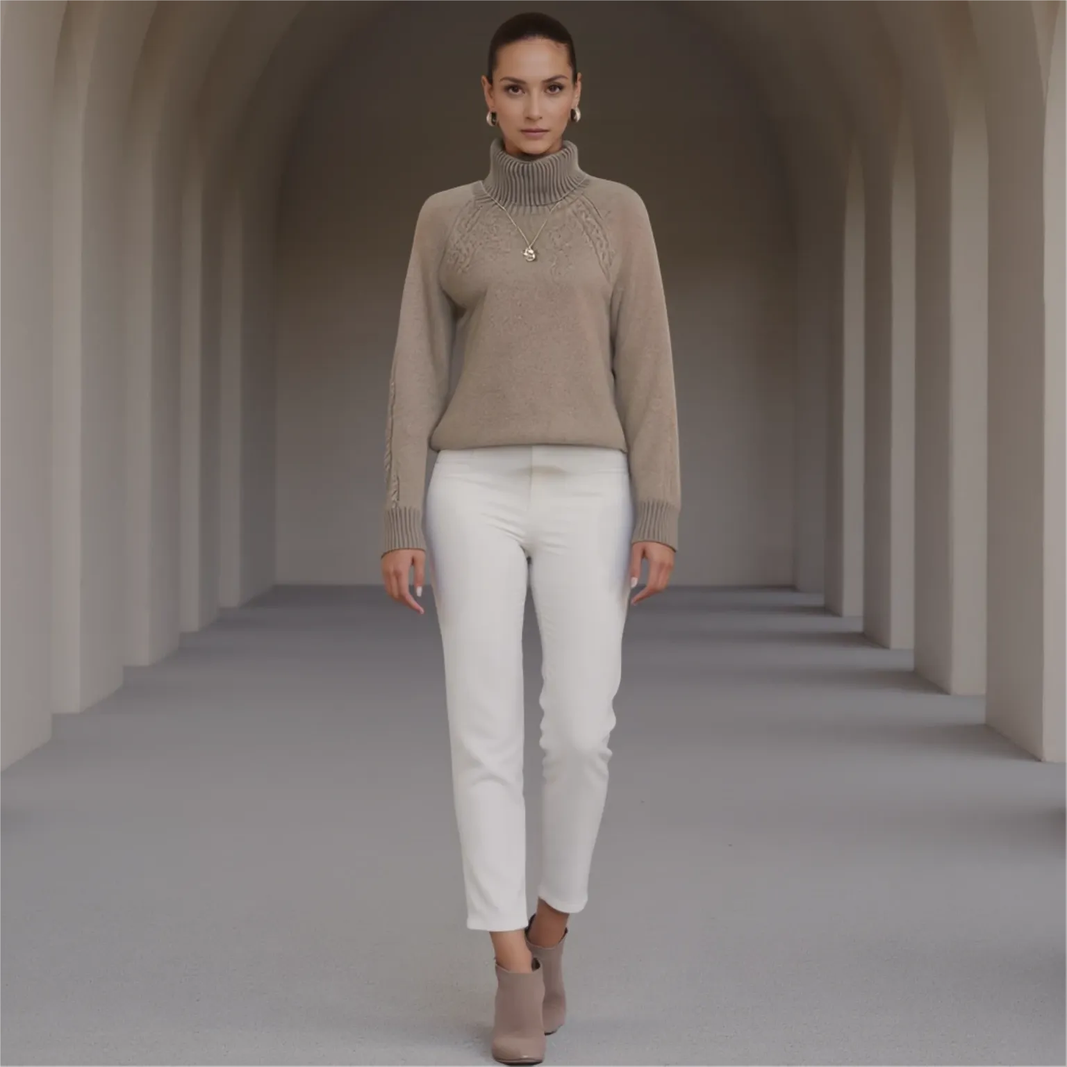 Woman wearing a beige turtleneck sweater and white pants in a tunnel-like setting